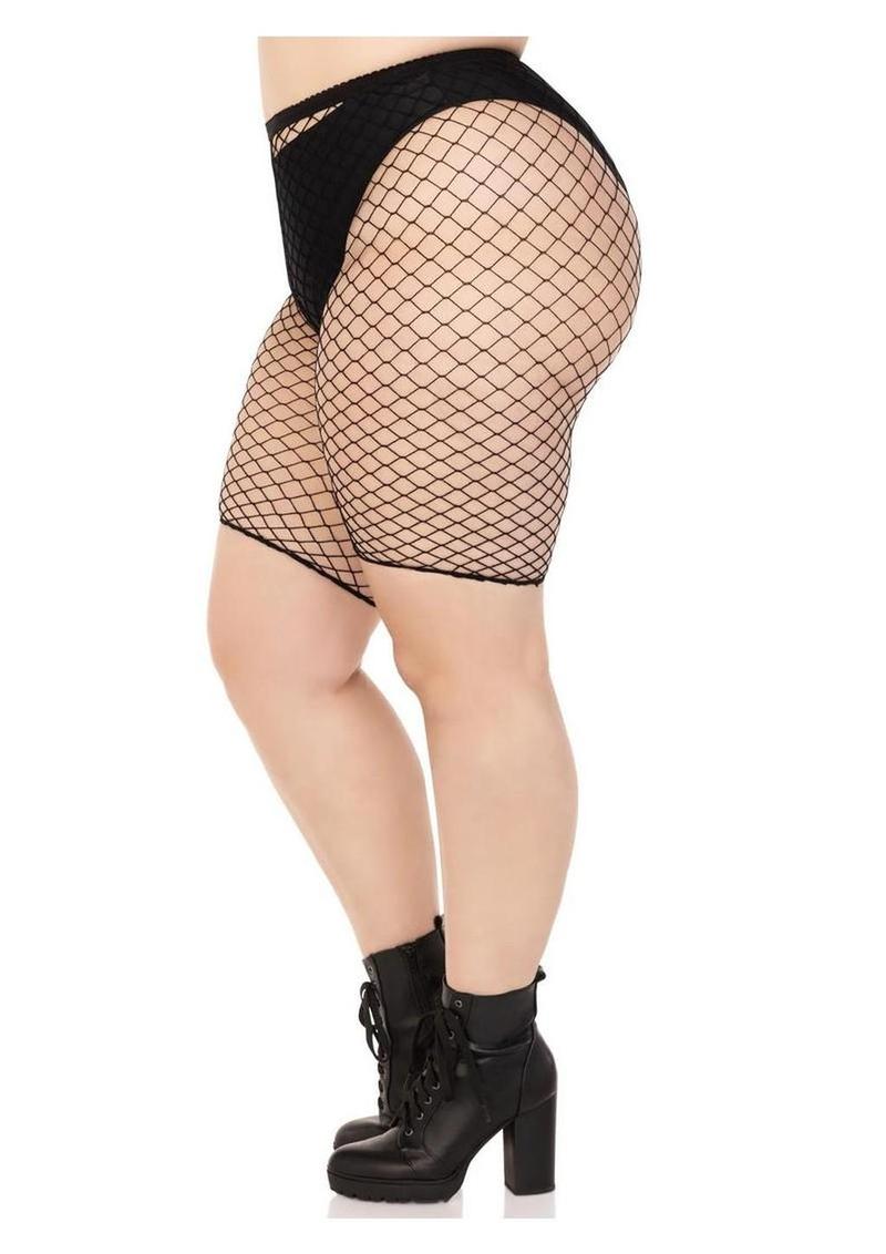 Person wearing black fishnet stockings and black high-heeled boots on a white background