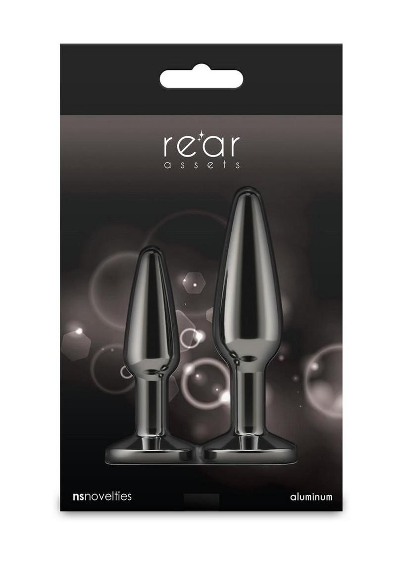 Packaging of 'rear assets' with two black butt plugs on a dark background.